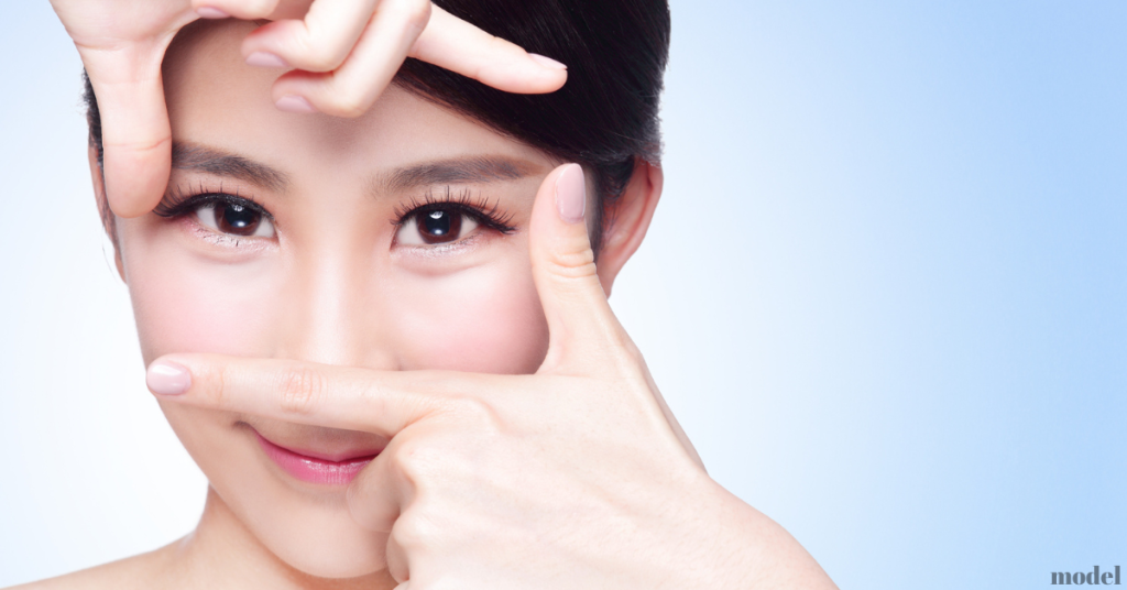 asian woman making a rectangle around her eyes using her fingers (model)